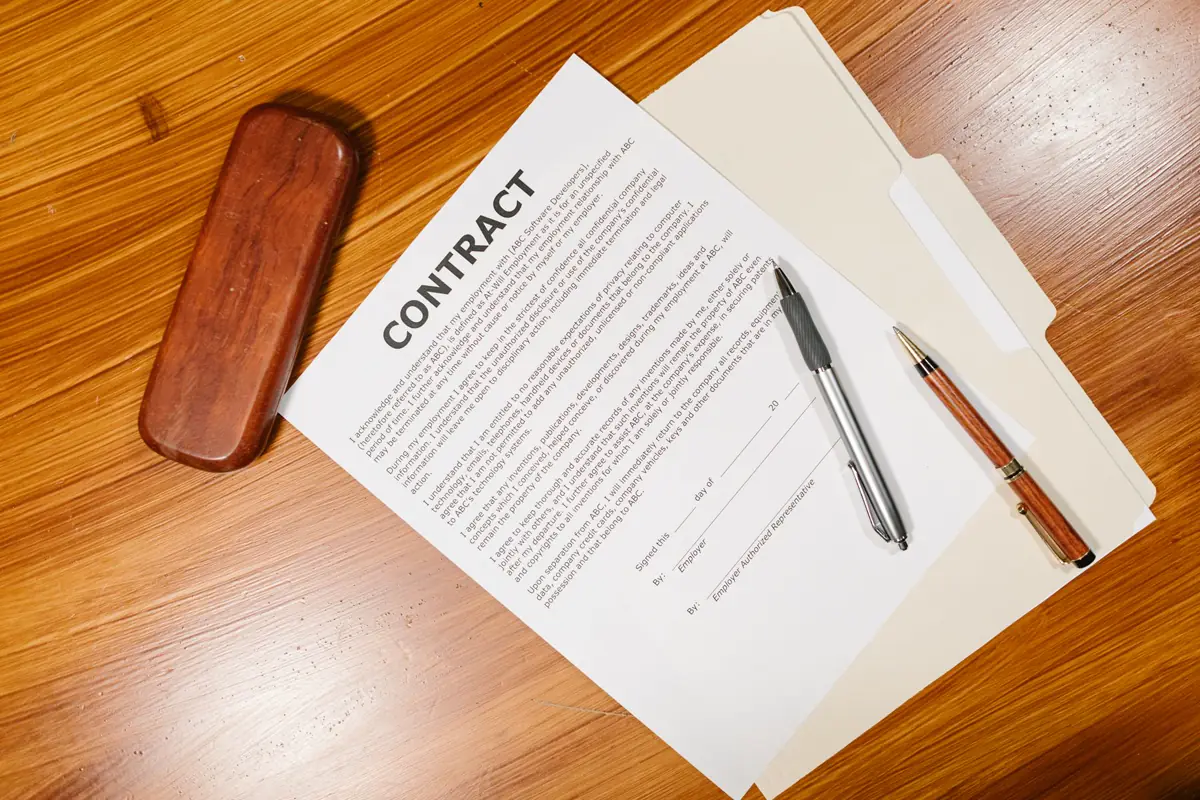 Contrats et documents de travail réunis sur une table.